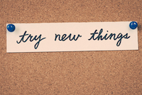 A note tacked to a corkboard with the words "try new news"