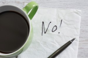 Coffee cup on top of a napkin with the word 'No!' scrawled on it. 